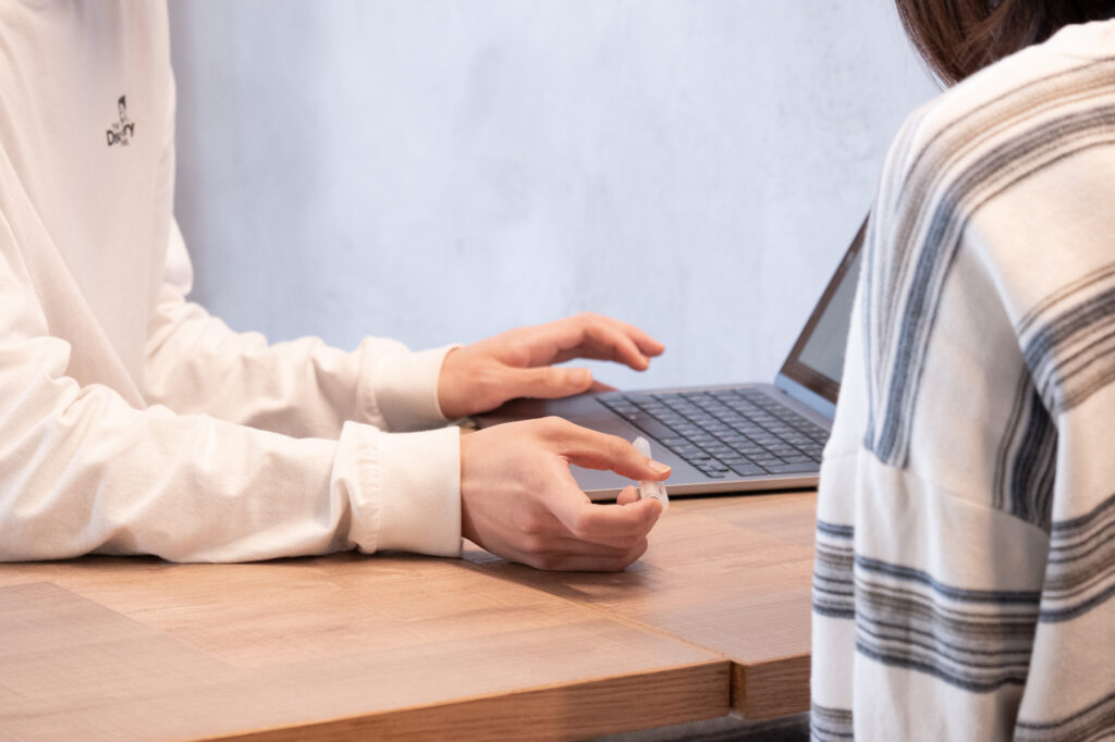 パソコンを見ながら相談する2人