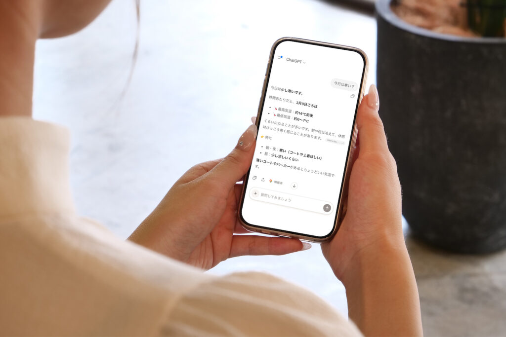 スマホを手に持ち生成AIに質問をする画像